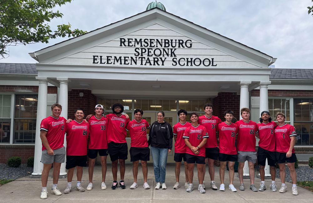 Aviator players and coach standing in front of Remsenburg Speonk Elementary School