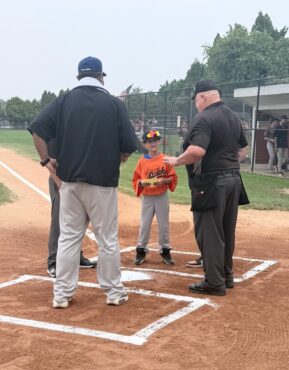 Young boy at baseball game meeting officials