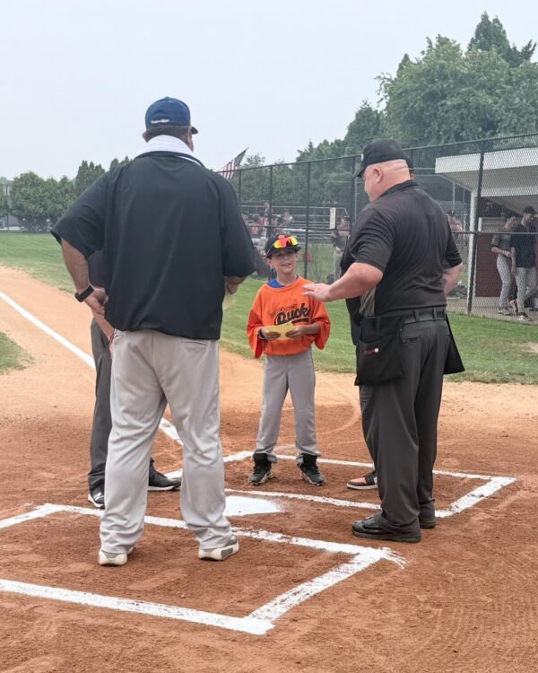 Young boy at baseball game meeting officials